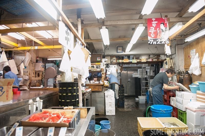 Experience and photos at Tsukiji Fish Market in Tokyo, Japan by Sometimes Home Travel Blog. Picture of vendors stands in the market.