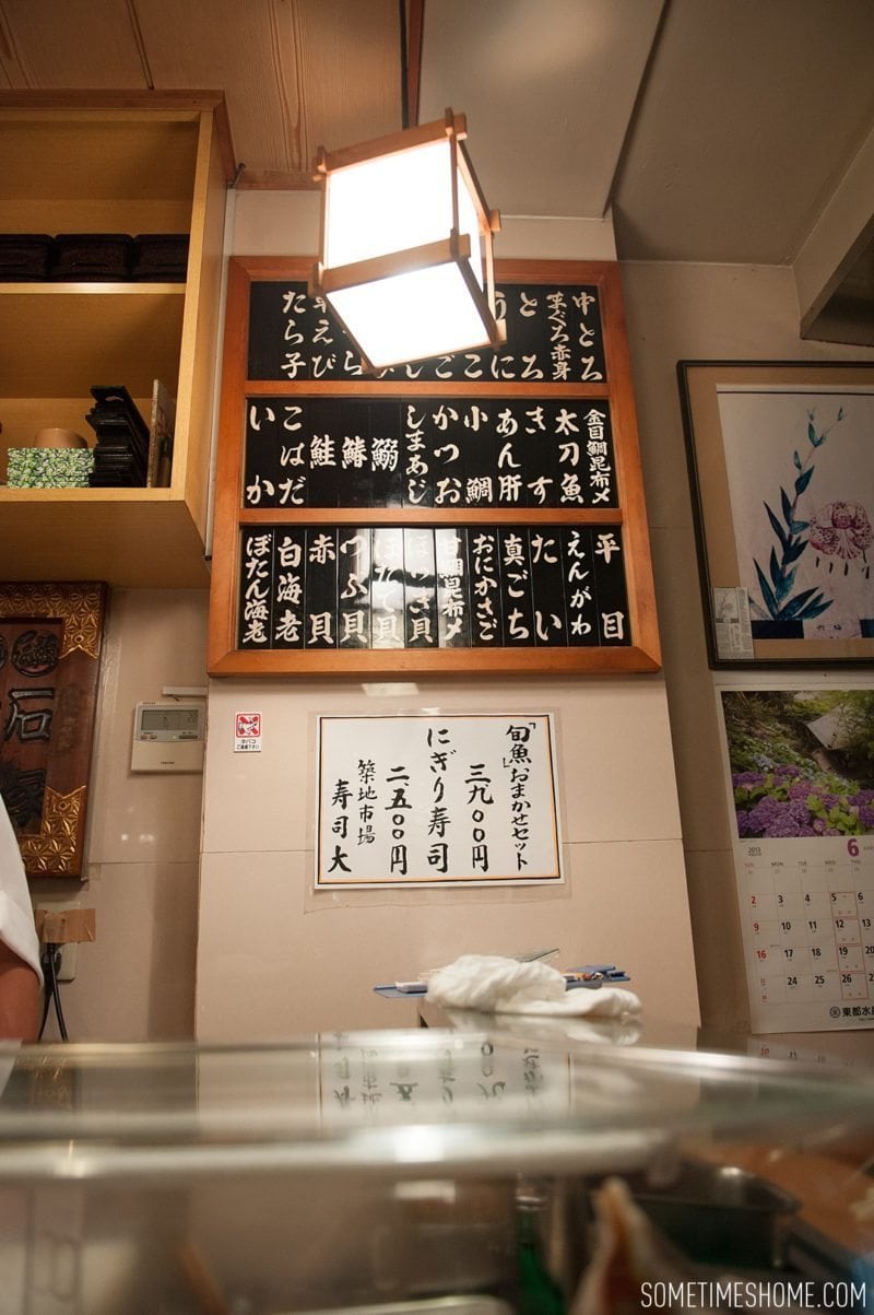 Sushi Dai Restaurant at Tsukiji Fish Market in Tokyo Japan. Photos on Sometimes Home travel blog with the board of options in Japanese.