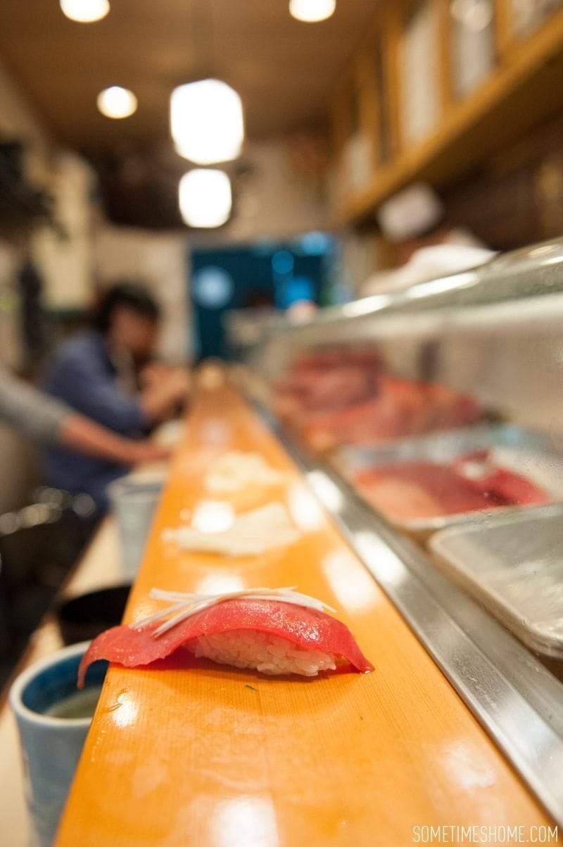 Sushi Dai Restaurant at Tsukiji Fish Market in Tokyo Japan. Photos on Sometimes Home travel blog with a picture of tuna at the bar.