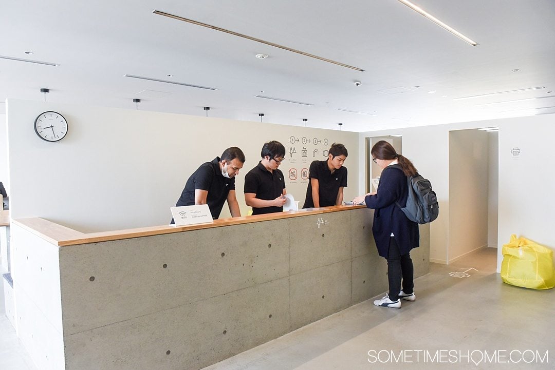 What It's Like to Stay in 9 Hours Pod Hotel in Shinjuku Japan by Sometimes Home travel site. A look inside and advice, pros and cons. Photo of the check in desk.