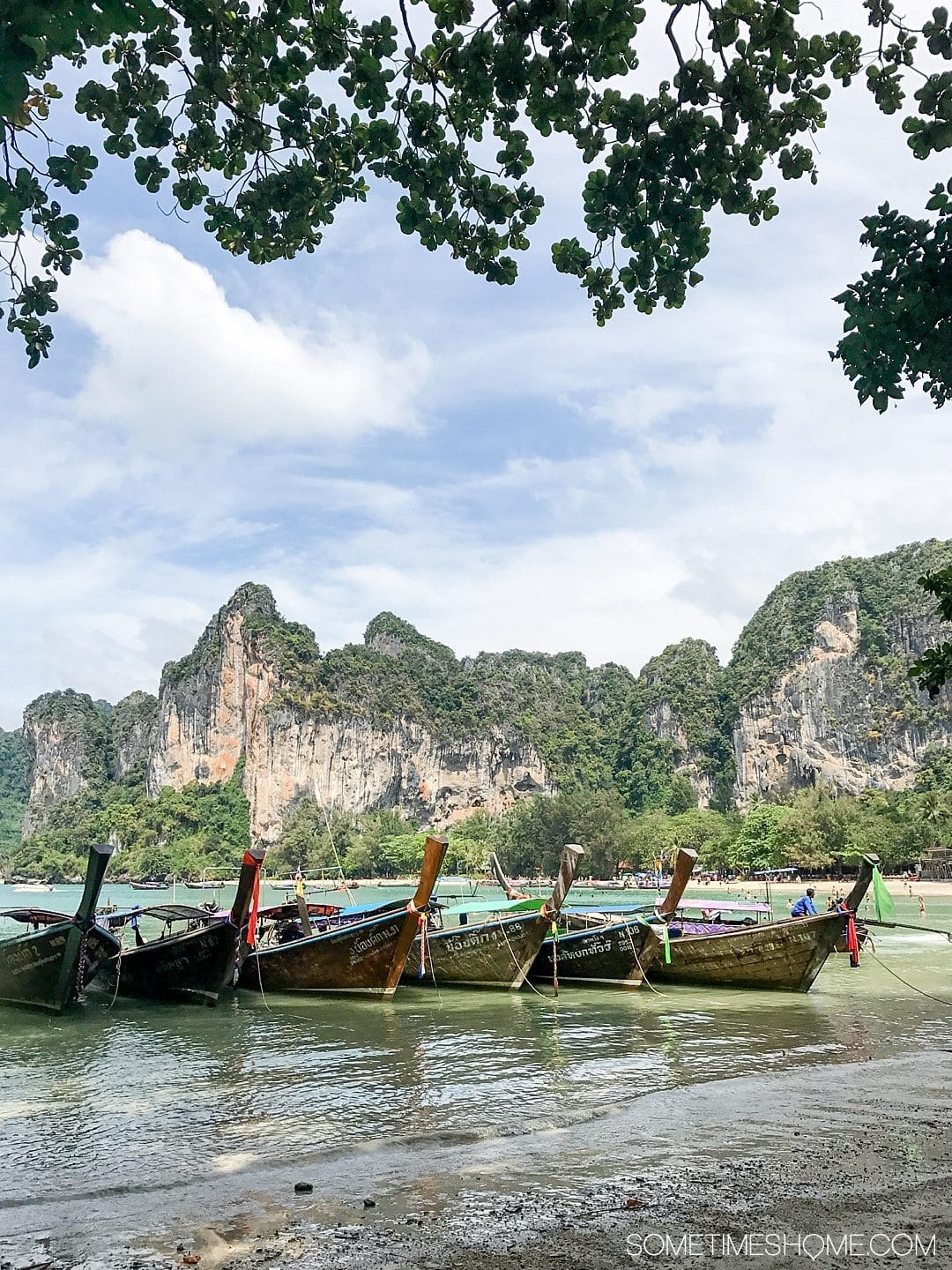 The BEST excursion we did in Thailand was a day rock climbing Phuket with an amazing guide. Our destinations were Krabi and Railay Beach on our day trip itinerary. Our adventure between the islands was a wonderful thing to do on a mid-size budget. Learn about our cost (for solo and couples) and see photography and more on Sometimes Home. #ThailandTravel #PhuketThailand #RailayBeach #KrabiBeach #RockClimbing #ThailandRockClimbing #ThingstodoinPhuket #ThaiBeaches #SoutheastAsiaTrip #RockClimbingThailand