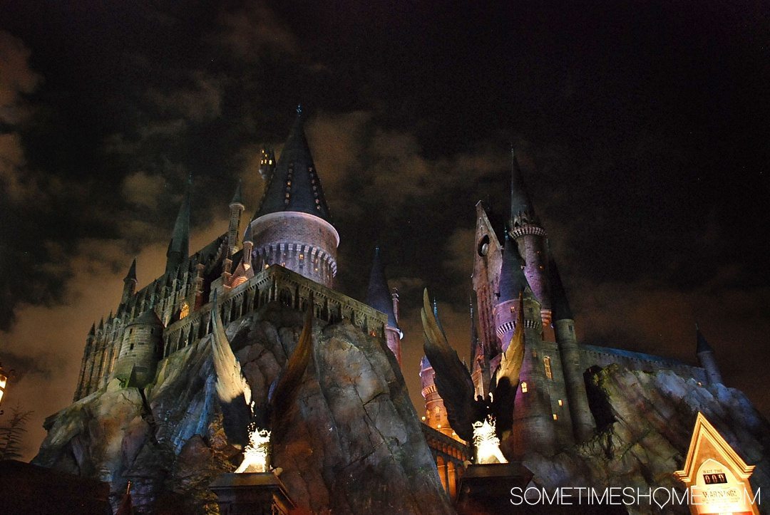 5 Mistakes to Avoid at the Wizarding World of Harry Potter in Orlando, Florida by Sometimes Home travel blog. Photo of Hogwarts Castle at night.