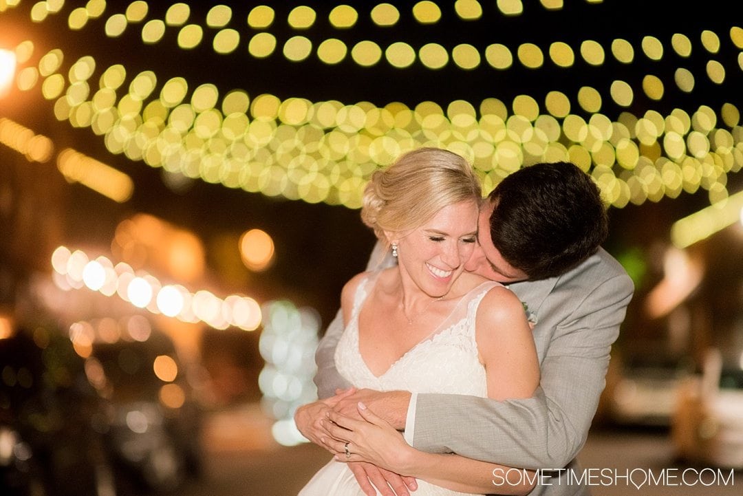 10 Best Downtown Raleigh Photography Spots on Sometimes Home travel blog. Photo of City Market cobblestone street with strung overhead lights with a bride and groom.