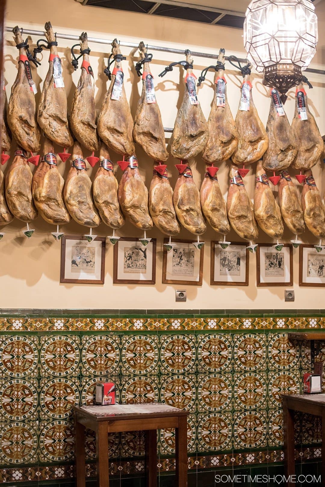 One Perfect Day in Granada Spain. Photos and itinerary on Sometimes Home travel blog. Picture of hanging ham legs from Bodegas La Mancha restaurant.