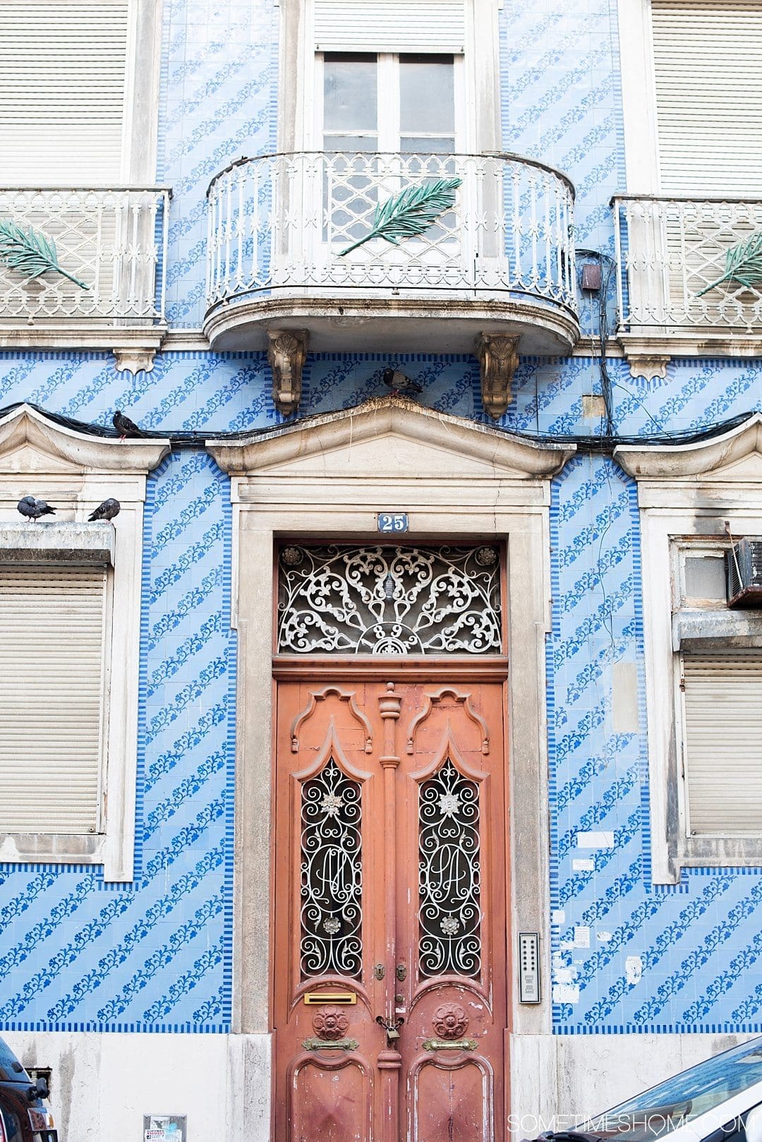 Why Lisbon is the Best City in Europe on Sometimes Home travel blog. Photo of blue hand painted tiles on the facade of a building.