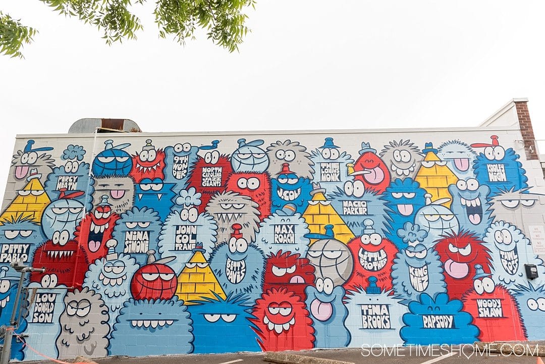 10 Best Downtown Raleigh Photography Spots on Sometimes Home travel blog. Photo of a mural wall by Kevin Lyon of colorful monsters in red, blue, grey and white near Trophy Brewing.