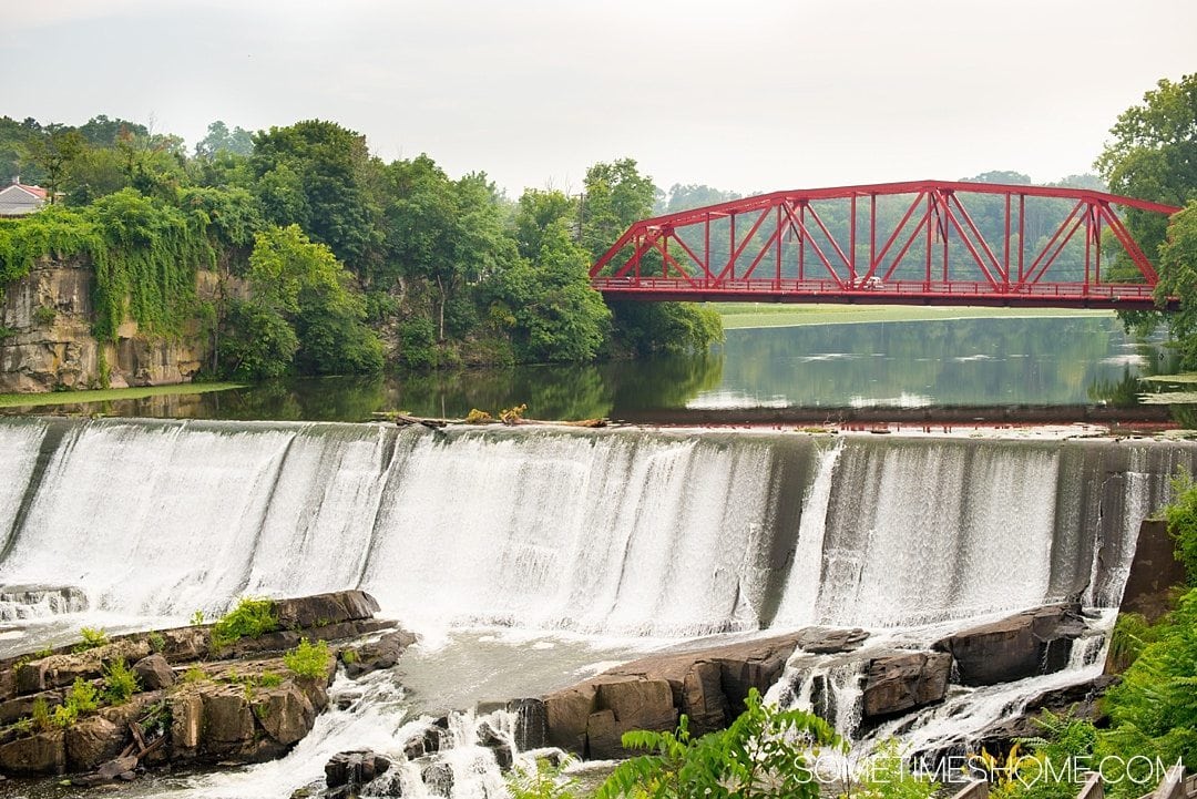 Your Complete Guide to Saugerties, New York on Sometimes Home travel blog. Photo of the Esopus Creek waterfalls view from Diamond Mills Hotel.