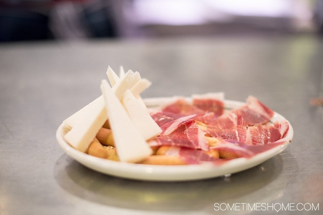 Eat Your Way Through Seville on Sometimes Home travel blog. Photo of a plate of jamon and manchego cheese.