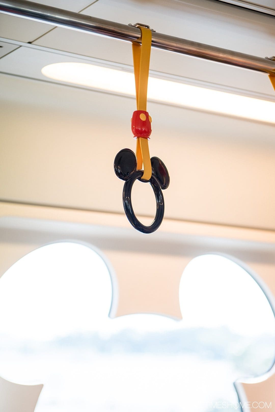 The Ultimate First-Timer's Guide to Tokyo DisneySea on Sometimes Home travel blog. Photo of a Mickey Mouse head hand hold and window on a monorail car.
