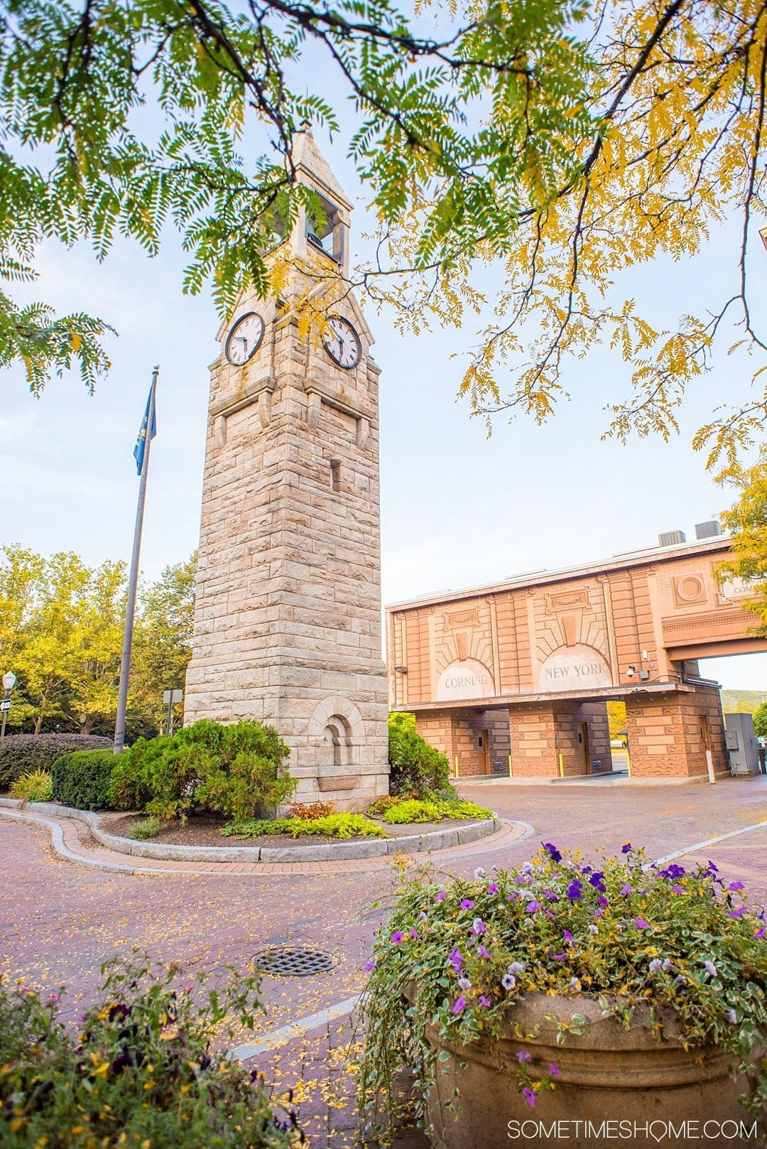 Things to do in Corning NY in the Finger Lakes region on Sometimes Home travel blog. Photo of the downtown clocktower and painting bearing the town's name.