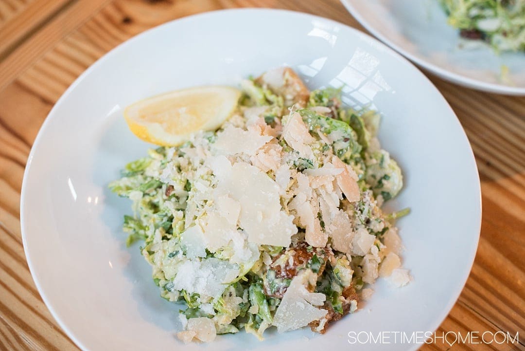 Photos of East Aurora New York will inspire you to visit this town. It's 20 miles outside of Buffalo, NY and is filled with great food, things to do and photography spots, whether along it's Americana Main Street or in the surrounding area. The seasonal menu at Elm Street Bakery is worth a visit alone, like this shredded Brussels Sprouts Caesar salad! Click through for more on where to eat, play and stay! #TravelBUF #VisitBuffalo #EastAuroraNY #EastAurora #EastAuroraNY #BuffaloNiagara #ArtsandCraftsMovement #ElmStreetBakery #BrusselsSprouts #CaesarSalad