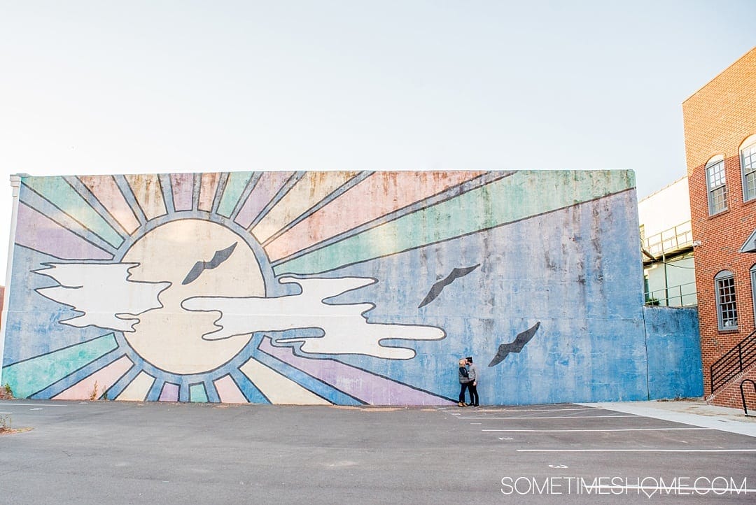 The 12 Best Photography Spots in Durham, North Carolina include art, greenery, a very special part of Duke campus and more. Click through to read the specifics on this downtown colorful, blue sunrise mural on Sometimes Home! #DurhamNC #NorthCarolina #DurhamNorthCarolina #Duke #VisitNC #photographyspots #photography