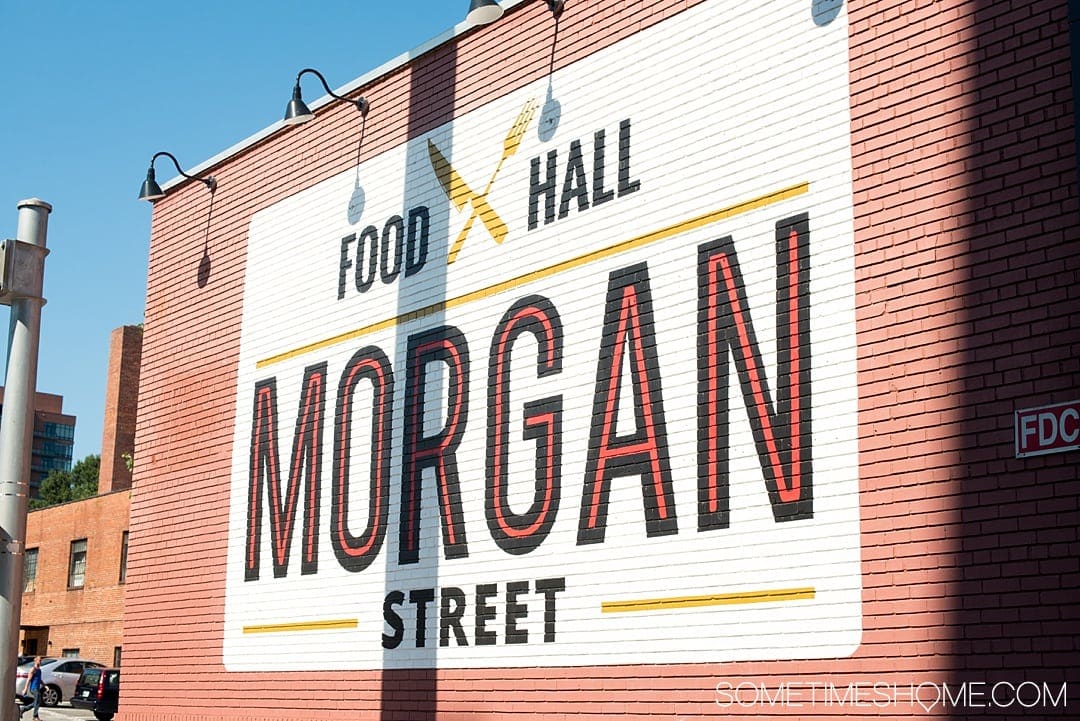 One of the best things to do in the capital of North Carolina is visit Morgan Street Food Hall in Raleigh! This downtown attraction has a ton of restaurant's food options and assorted shopping in the warehouse neighborhood. If you're moving soon or have been a long time resident there's something for everyone. Click through for photography and info on Sometimes Home! #sometimeshome #MorganStreetFoodHall #RaleighNC #downtownRaleigh #ThingstodoinRaleigh #RaleighNorthCarolina #DTRaleigh #FoodHalls