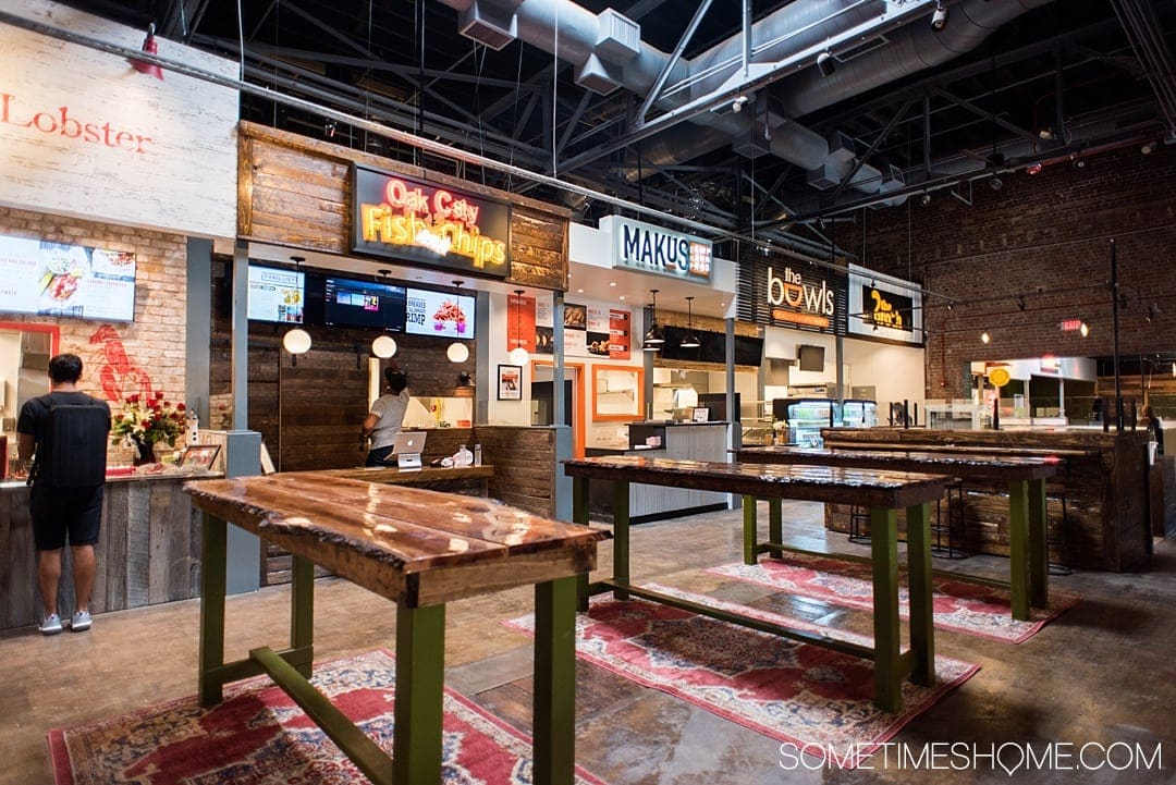 One of the best things to do in the capital of North Carolina is visit Morgan Street Food Hall in Raleigh! This downtown attraction has a ton of restaurant's food options and assorted shopping in the warehouse neighborhood. If you're moving soon or have been a long time resident there's something for everyone. Click through for photography and info on Sometimes Home! #sometimeshome #MorganStreetFoodHall #RaleighNC #downtownRaleigh #ThingstodoinRaleigh #RaleighNorthCarolina #DTRaleigh #FoodHalls