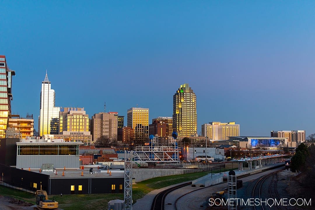 10 Best Downtown Raleigh Photography Spots on Sometimes Home travel blog. Photo of the Raleigh city skyline from Boylan Bridge. #downtownraleighphotography #raleighphotography #raleighphotographer