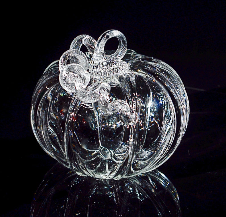 Clear glass blown pumpkin on a black background from SteubenCountyGlass on Etsy.