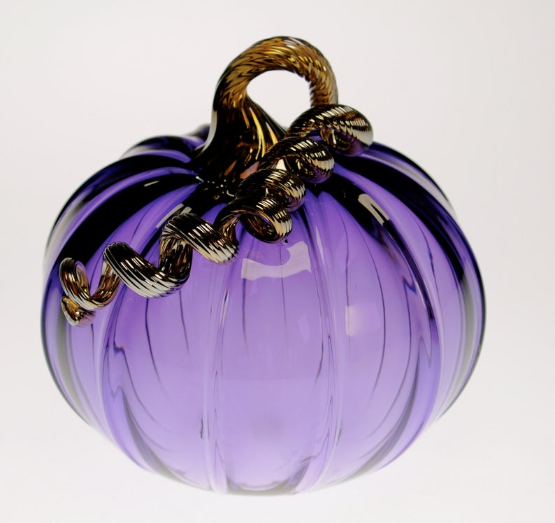 Purple glass blown pumpkin on a white background with a brown stem from SteubenCountyGlass on Etsy.