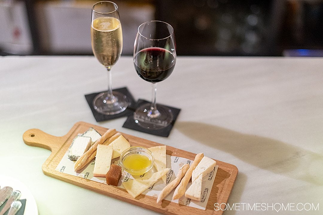 Plate of cheese and two glasses of wine, one white and one red