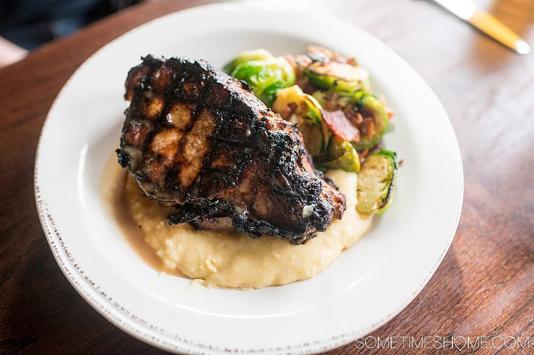 Grilled pork chop, grits and Brussels sprouts.