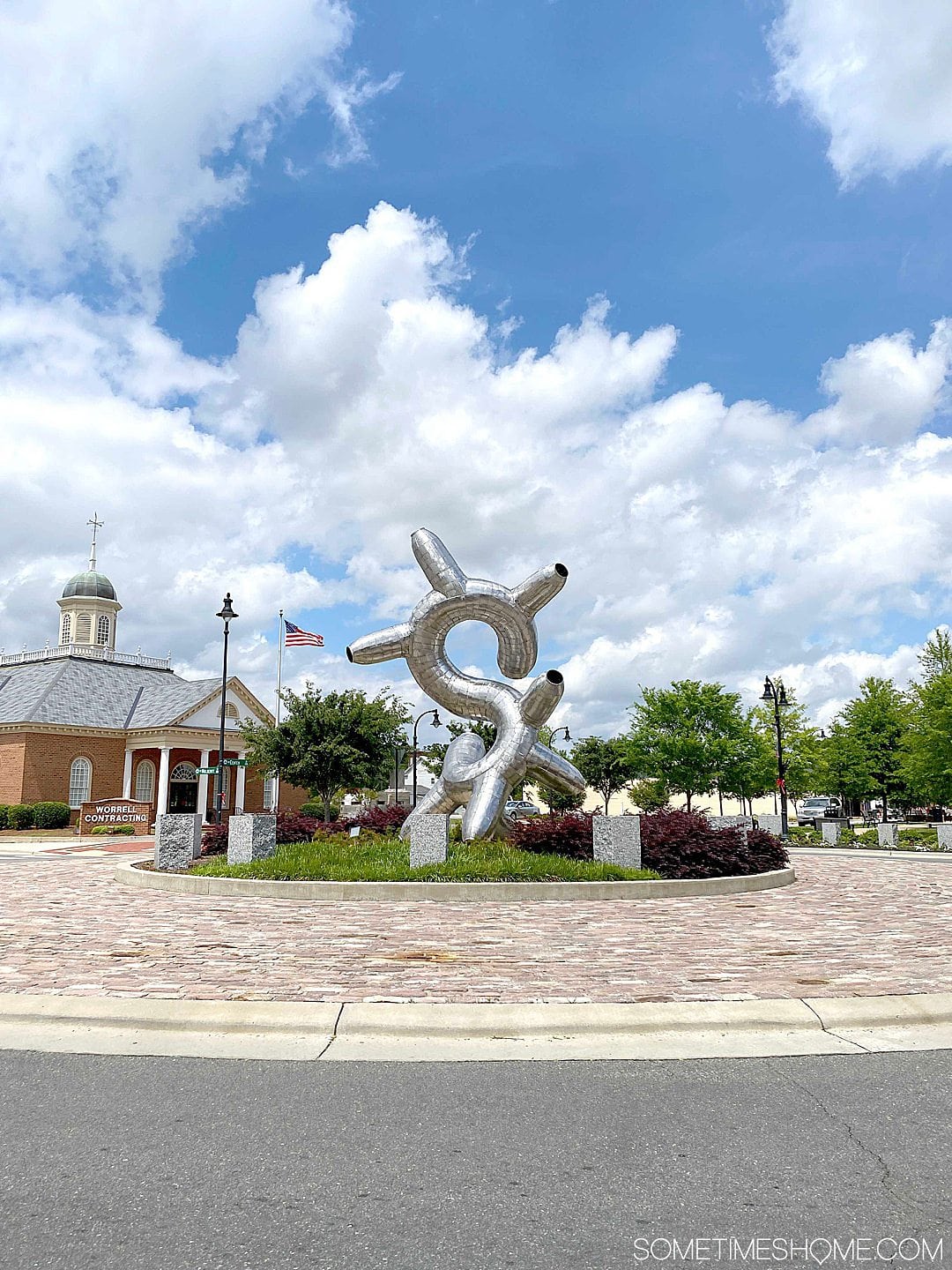 Sculpture on a main street with blue clouds