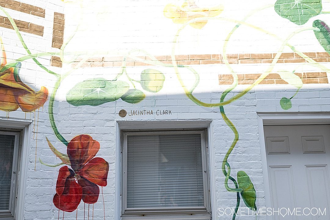 Colorful mural with orange flowers on a white wall