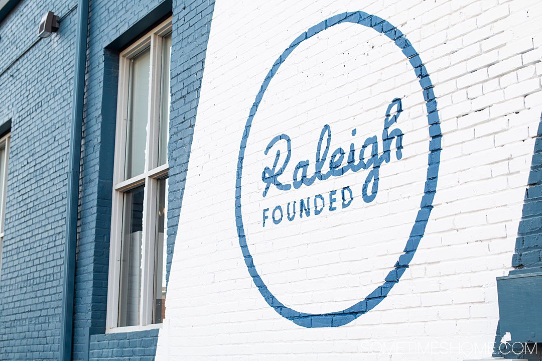 Raleigh founded painted on a wall in blue and white paint.