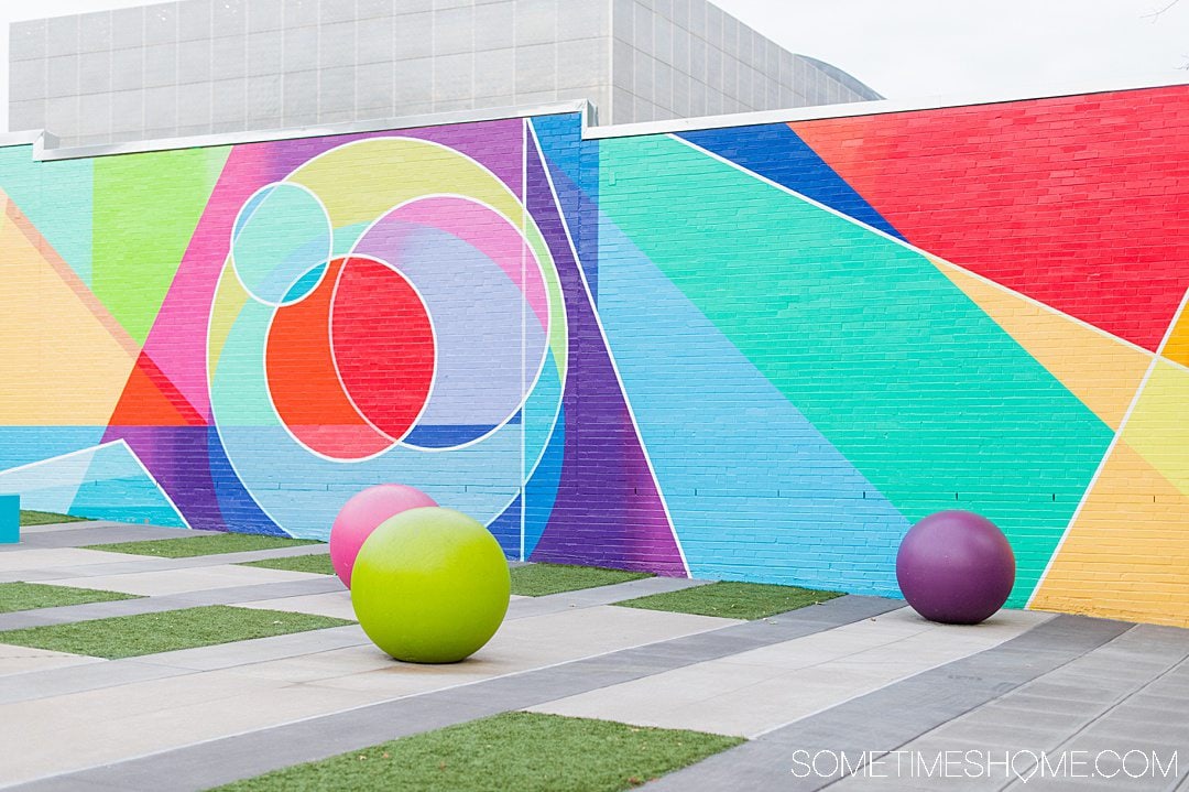 Colorful geometric mural in downtown Raleigh with various shapes including circles, triangle, and lines.