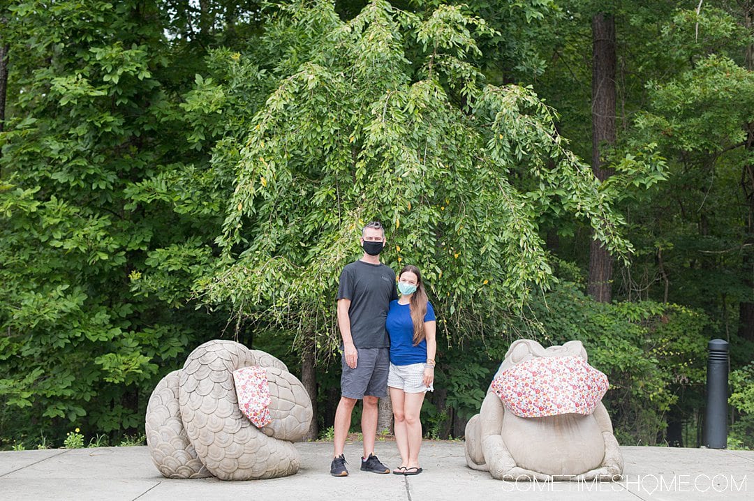 A couple with animal sculptures with masks on in Chapel Hill.