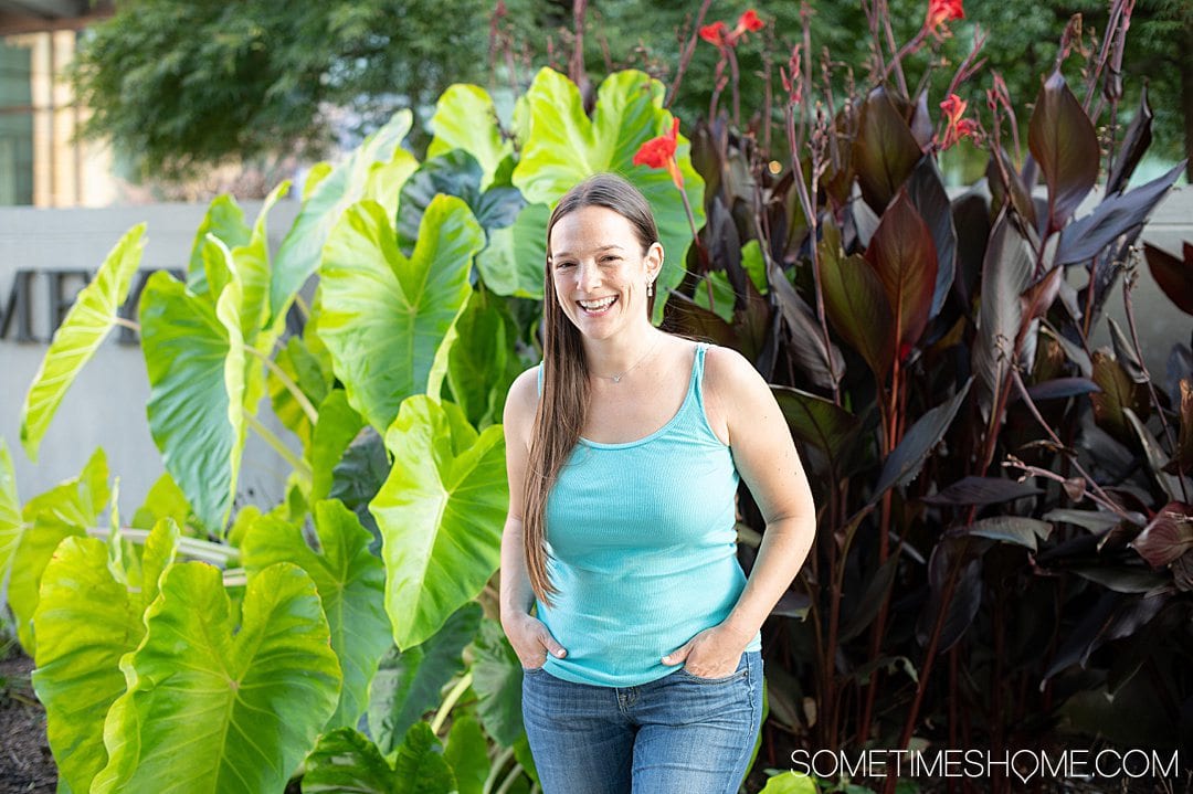 Women in front of green and purple tropical leaves in downtown Raleigh, NC.