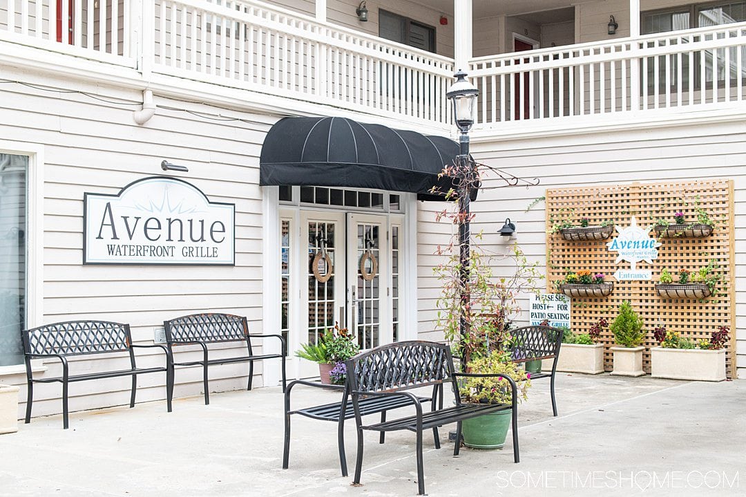 Front of the restaurant Avenue Waterfront Grill with a black awning, in Manteo in the Outer Banks.