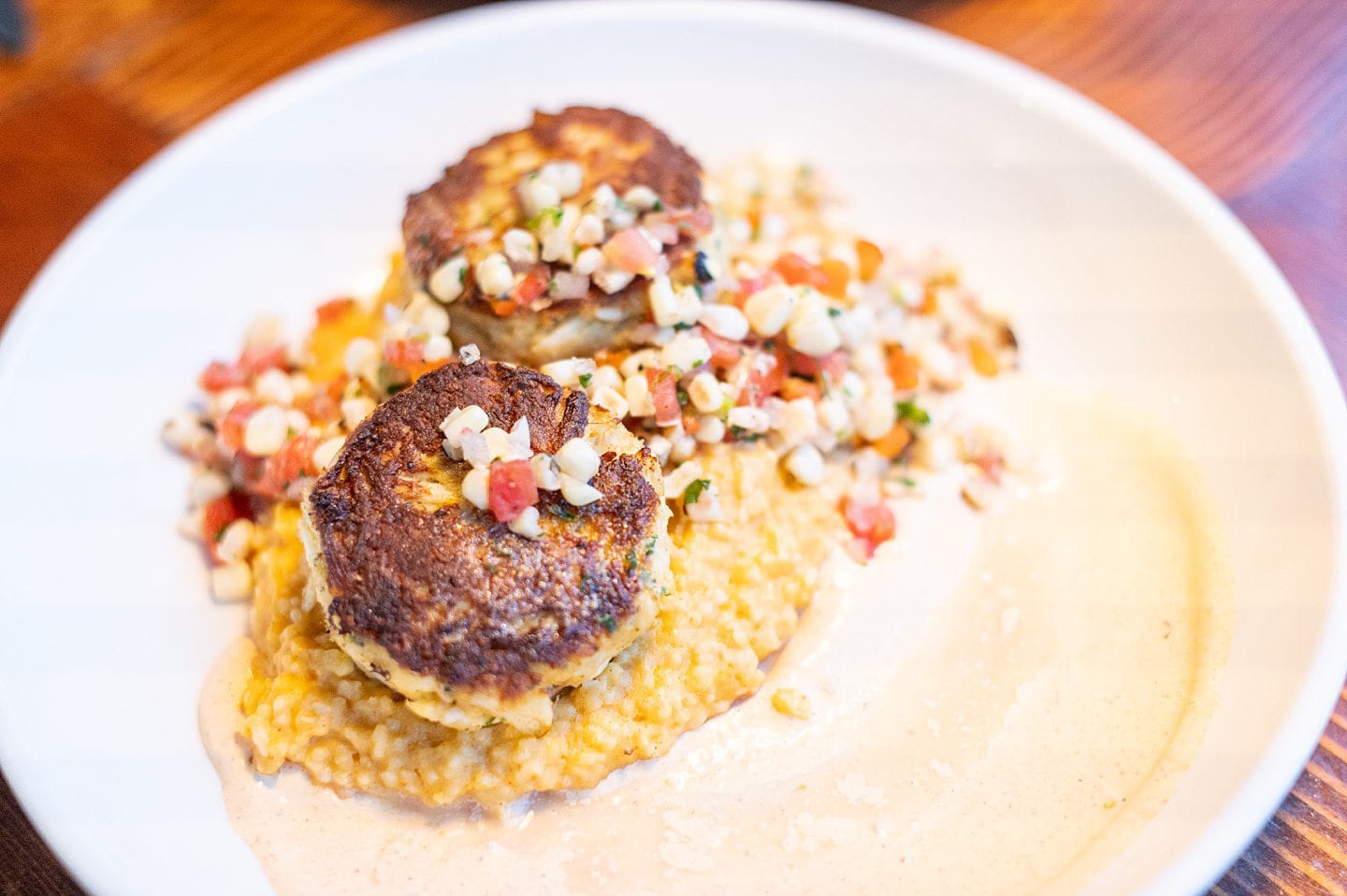 two lump crab cakes on top of cheesy grits with a corn salsa at Blue Water Grill in Manteo, NC.