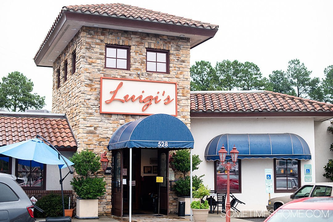 A restaurant facade with "Luigi's" on a sign above a blue awning in Fayetteville, NC.