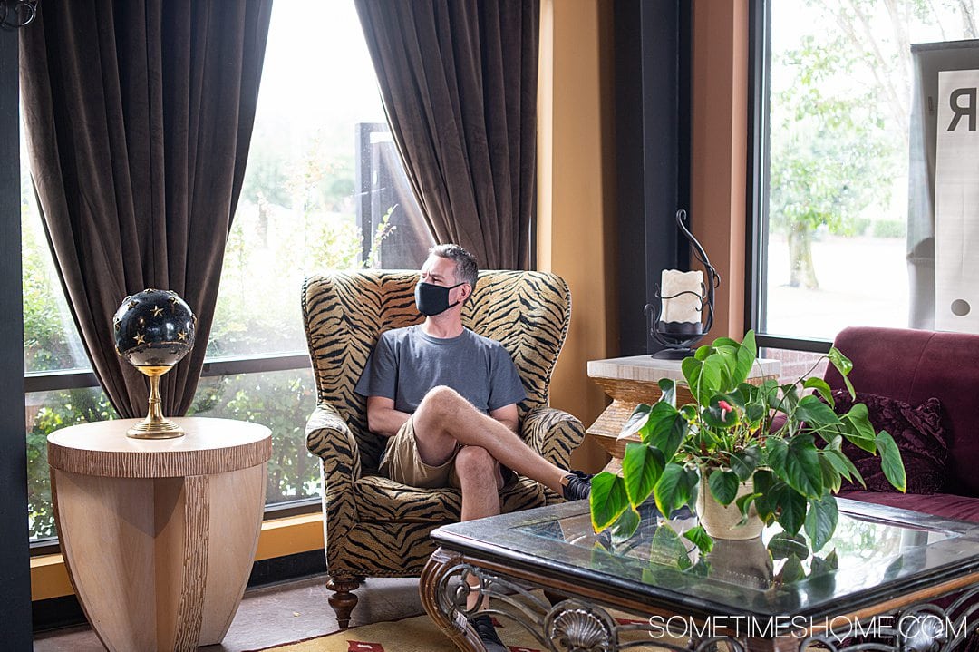 A man on a couch with curtains in the background at The Coffee Scene in Fayetteville, NC.