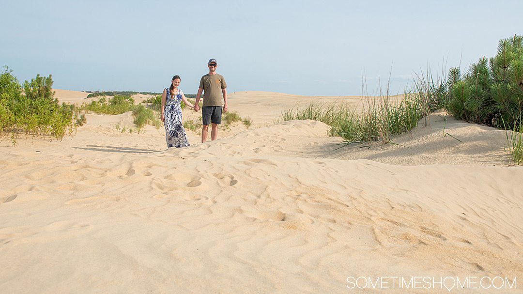 A couple in the sand dunes of Jockey's Ridge State Park in Nags Head, North Carolina in the Outer Banks.