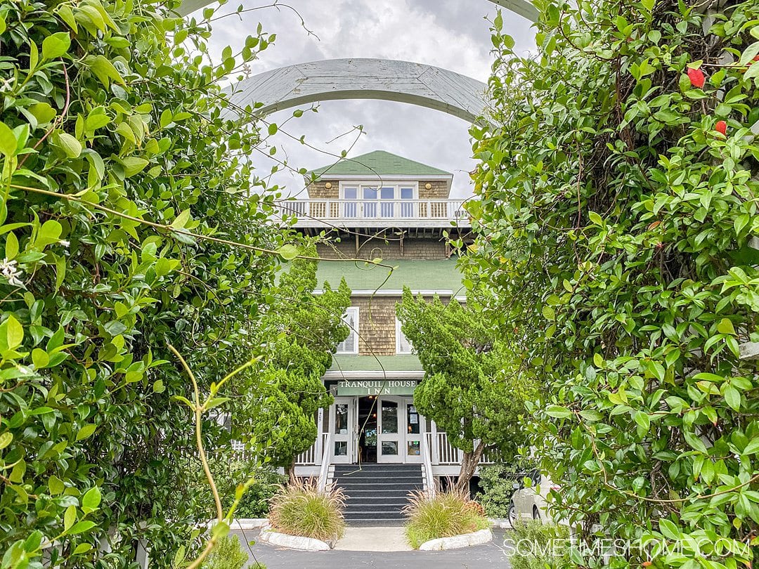 Tranquil House Inn hotel as seen through greenery and an archway in Manteo, on Roanoke Island in the Outer Banks of North Carolina.