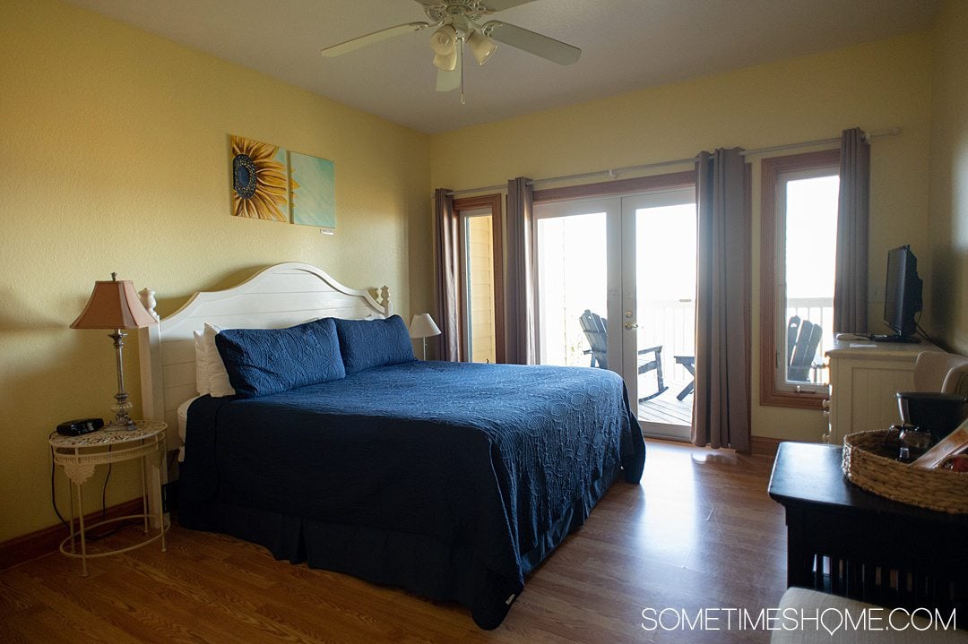 Room at the Inn on Pamlico Sound in Buxton, NC in the Outer Banks with a sunflower painting about the blue bed.