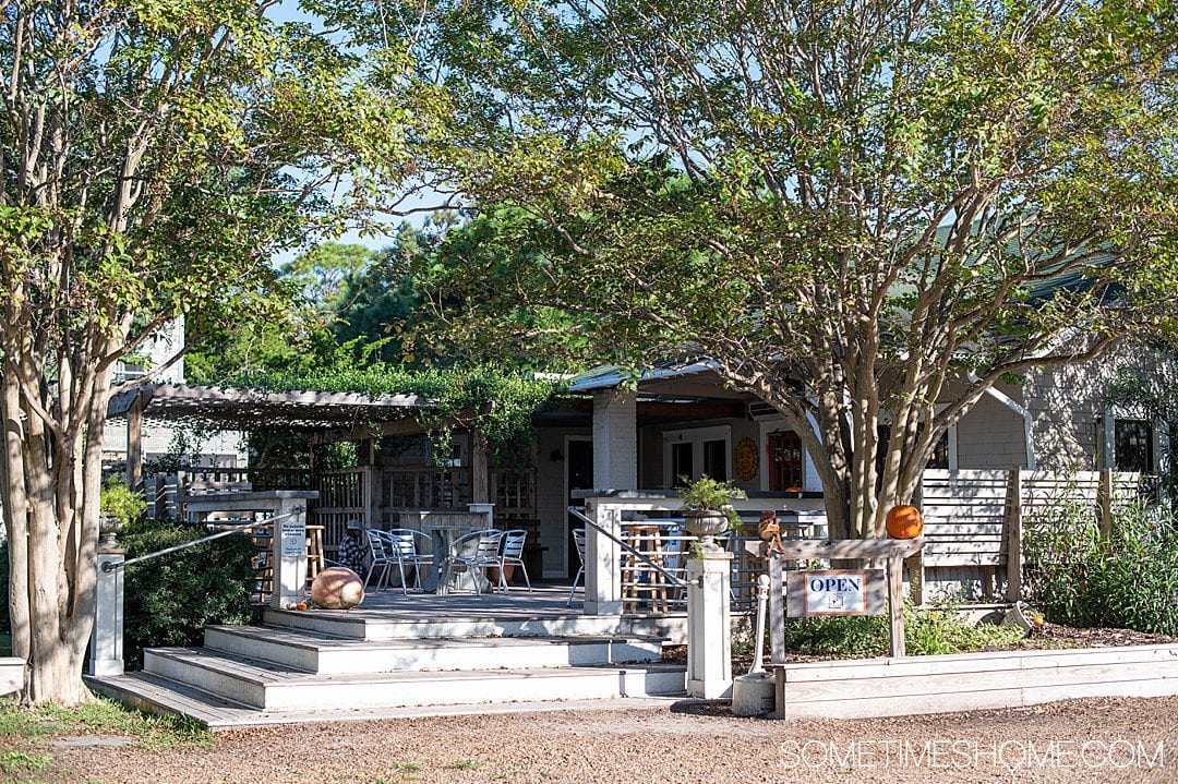 Ocracoke Coffee Company in the Outer Banks of North Carolina, with pumpkin on their outdoor porch for October, and greenery framing the deck.