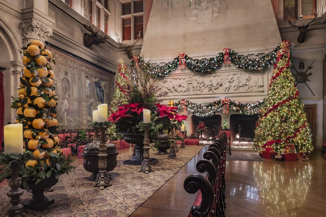 Interior of The Biltmore in Asheville, NC, decorated with garland and a Christmas tree.