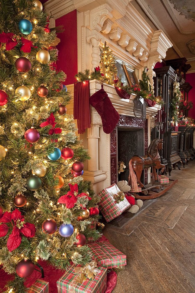 Stockings on a fireplace and a Christmas tree iwth colorful ornaments on the left of the photo at Korner's Folly near Winston-Salem, in Kernersville, NC.