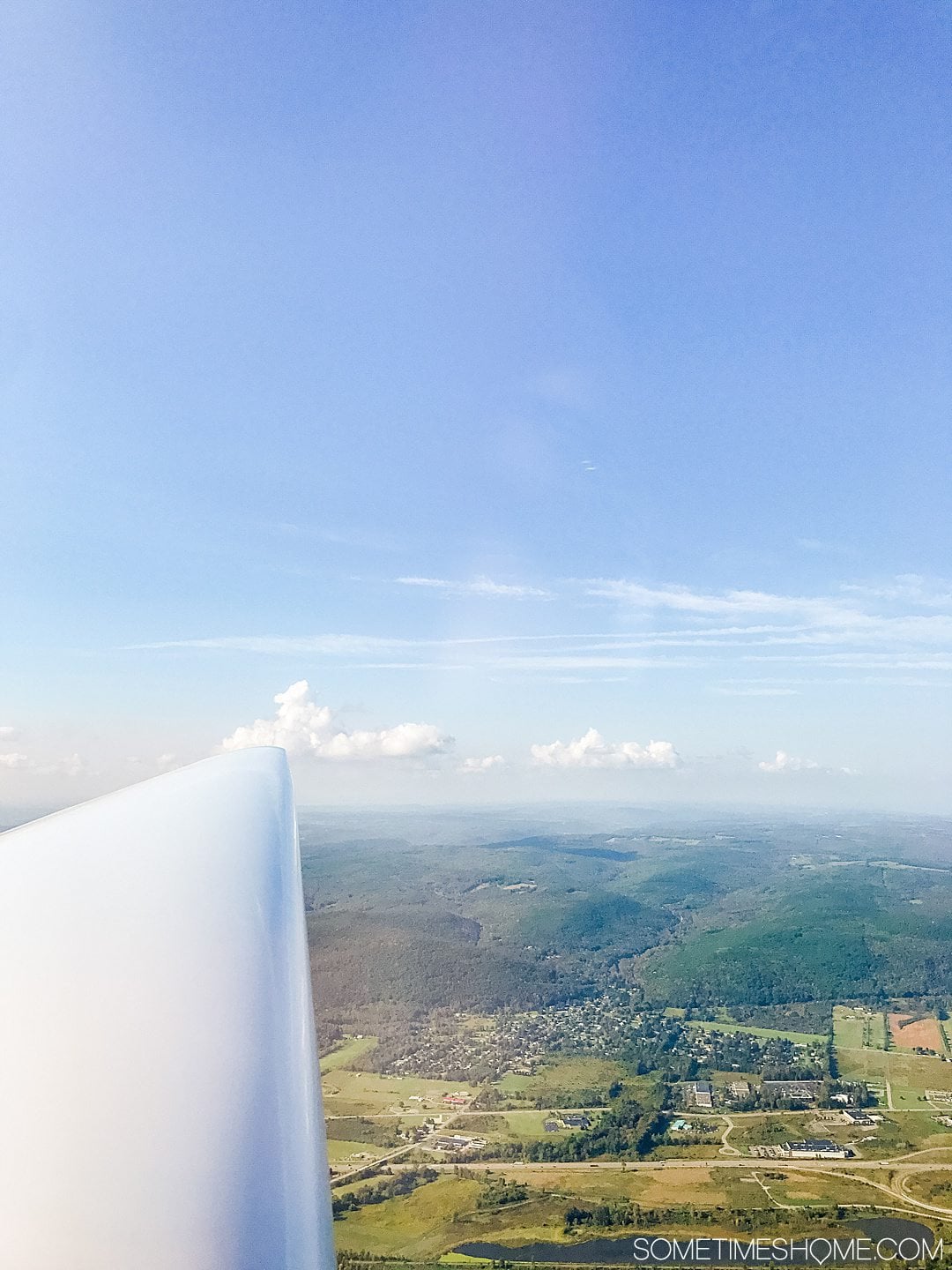The wing of a hang glider looking out to the greenery of the Finger Lakes in NY.