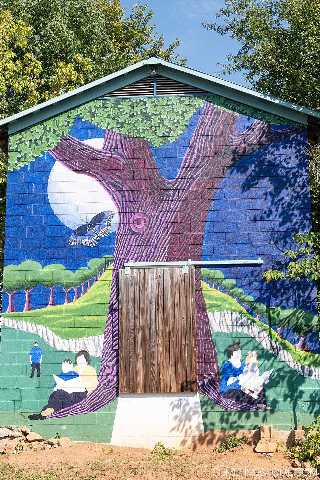 Things to do in Warrenton, NC include seeing this colorful blue and green tree mural.