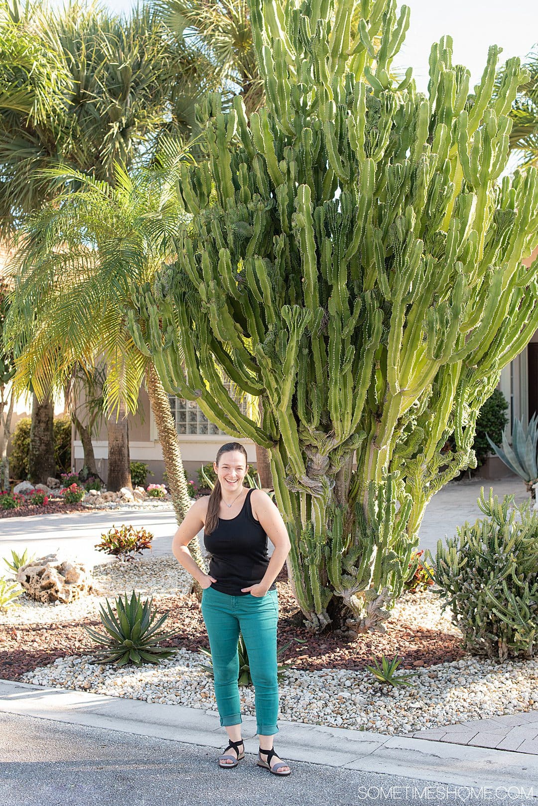 Woman in front of a cactus in teal pants and a black tank top for a Jambu shoes review.