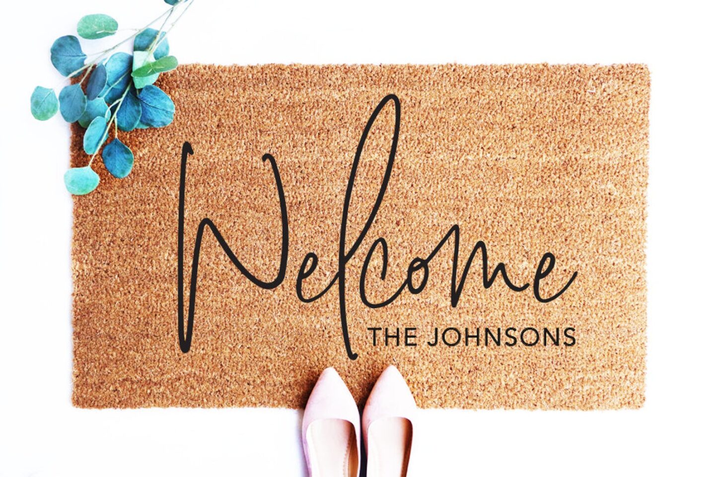 Welcome mat with "The Johnsons" in the lower right hand corner from an Etsy shop. 