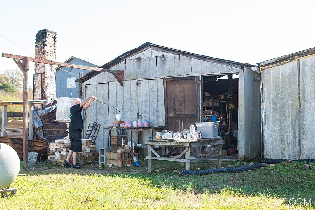 Potter at Turn and Burn pottery in Seagrove, NC, applying a design to vessels.