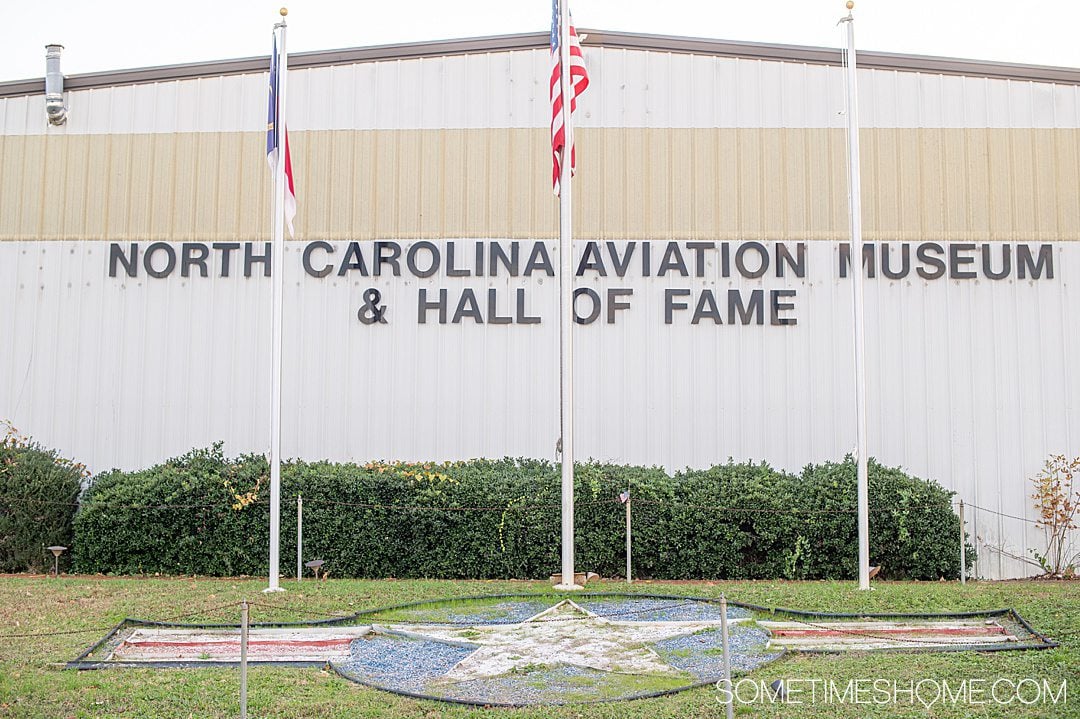 Front of the North Carolina Aviation Hall of Fame for Things to do in Asheboro, NC, with 3 flag poles.