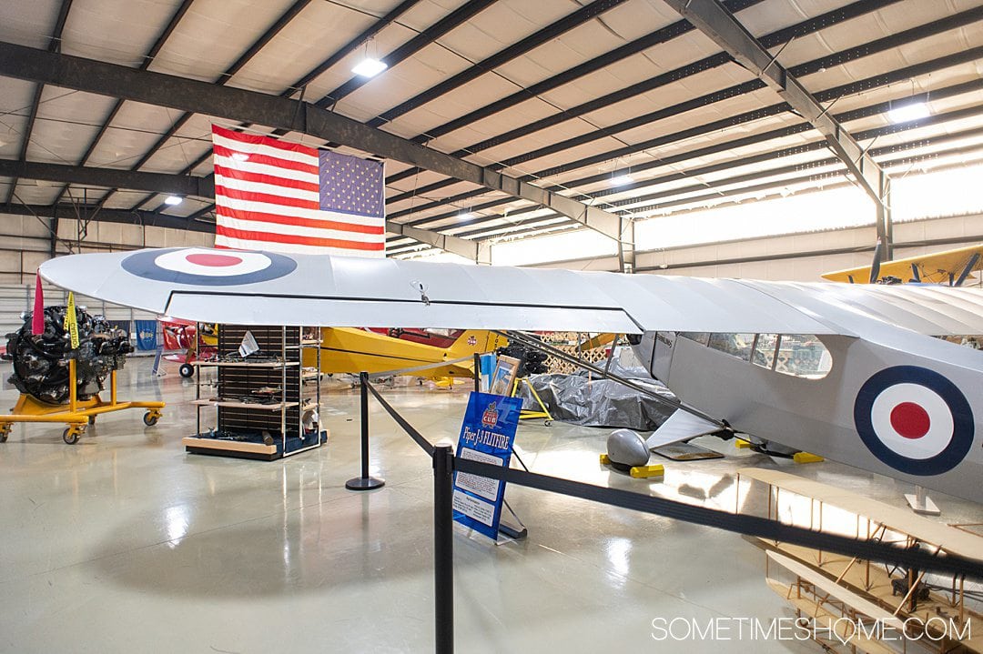 Old British plane with an American flag in the background, and at the NC Museum of Aviation in Asheboro, NC.