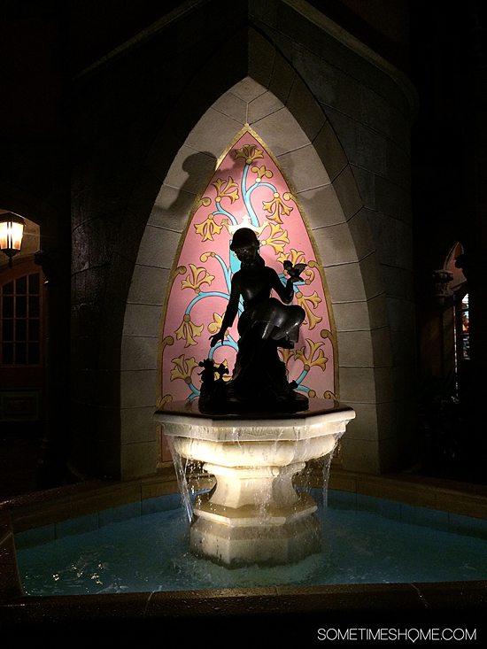 Silhouette of Cinderella at a fountain at night at Disney World.