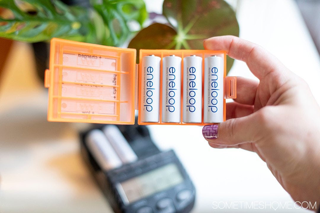 Orange battery holder with 4 white AA batteries. 