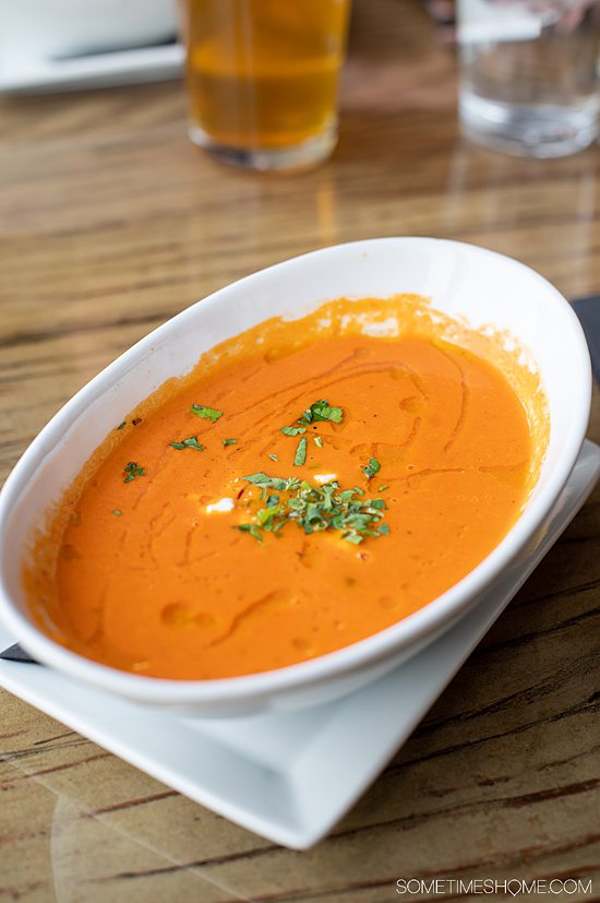 Oval bowl of tomato bisque soup with parsley sprinkled in the middle, at Pump House at Riverwalk in Rock Hill, SC.