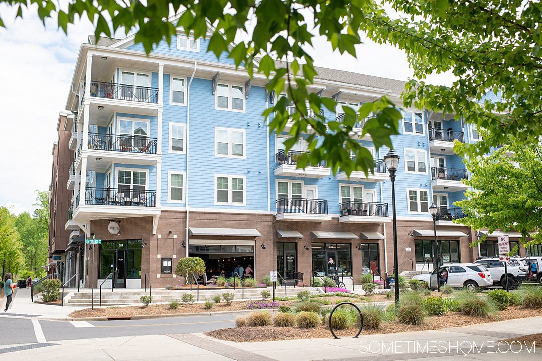 Blue building with a brick-covered ground level at Riverwalk in Rock Hill, South Carolina.